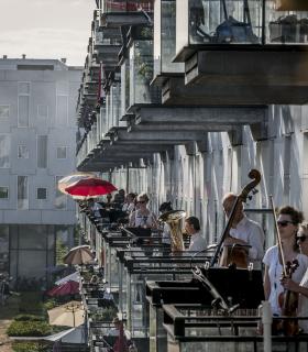 Photo de musiciens jouant sur les balcons d'un immeuble